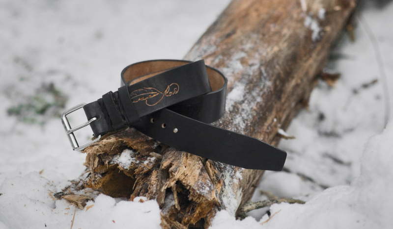 Black leather belt with carved feather image.