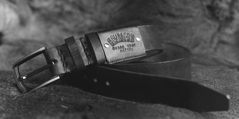 Black leather belt with carved Revalers logo.