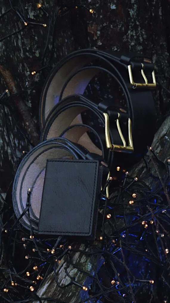 Three black belts in the tree branches, surrounded by small decorative sparkling lights.