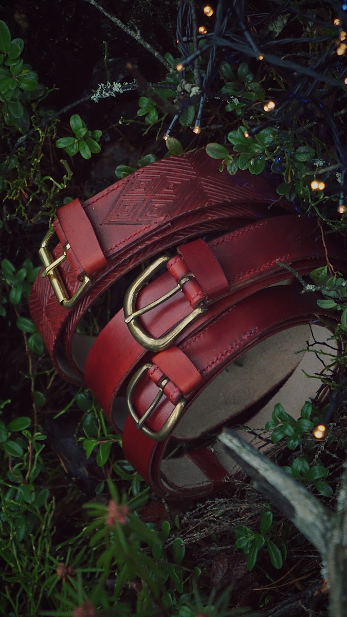 Three darker mahogany tone belts in the midst of dark green forest plants. There are few little sparkling lights on the right top corner.