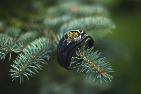 Leather bracelet is attached to the ring (as it would be fastened onto the wrist) and set onto the fir three branch.