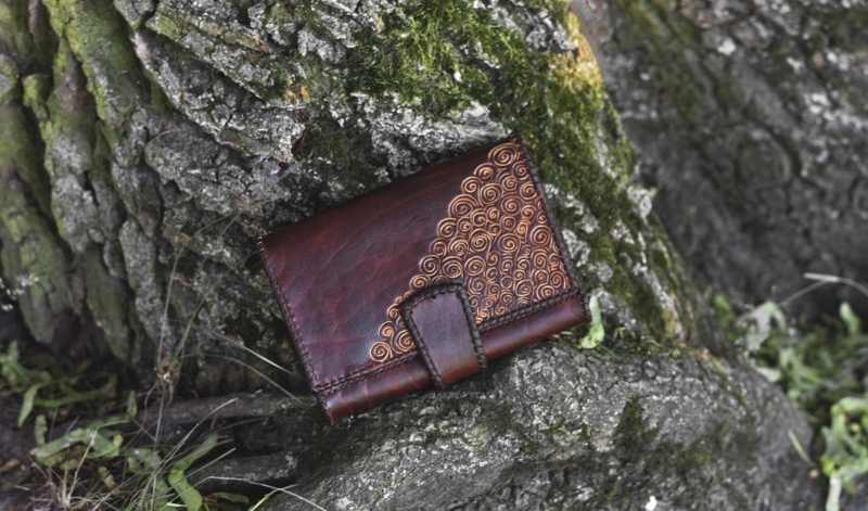 Large leather womens wallet with laced edges and hand carved pattern.