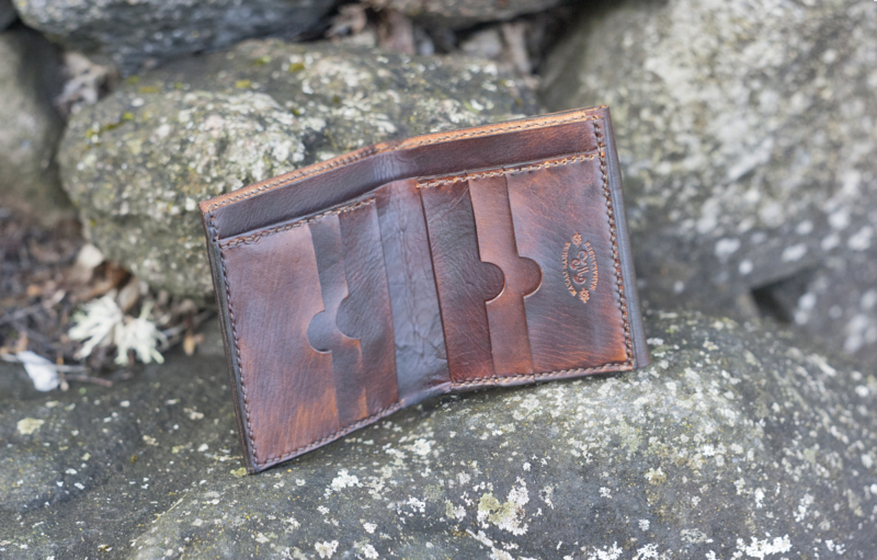 Dark brown leather wallet with a sailing ship image inside