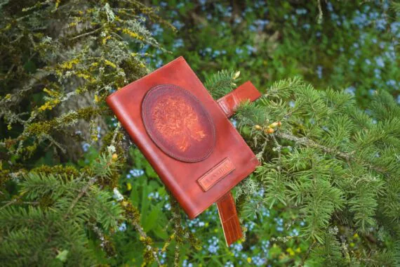 Märkmikukaaned on asetatud kuusepuu okste vahele. Kaantel on kaunistuseks nahale voolitud tammepuu aplikatsioon ning nimesilt.