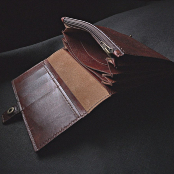 Rahakoti kaanele mahub neli ülestikust kaarditaskut, milliste all on veel üks laiem tasku. Rahakott kinnitub väikese rihmakese küljes oleva trukiga.